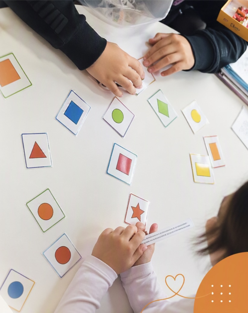 Enfants travaillant avec des cartes de formes colorées